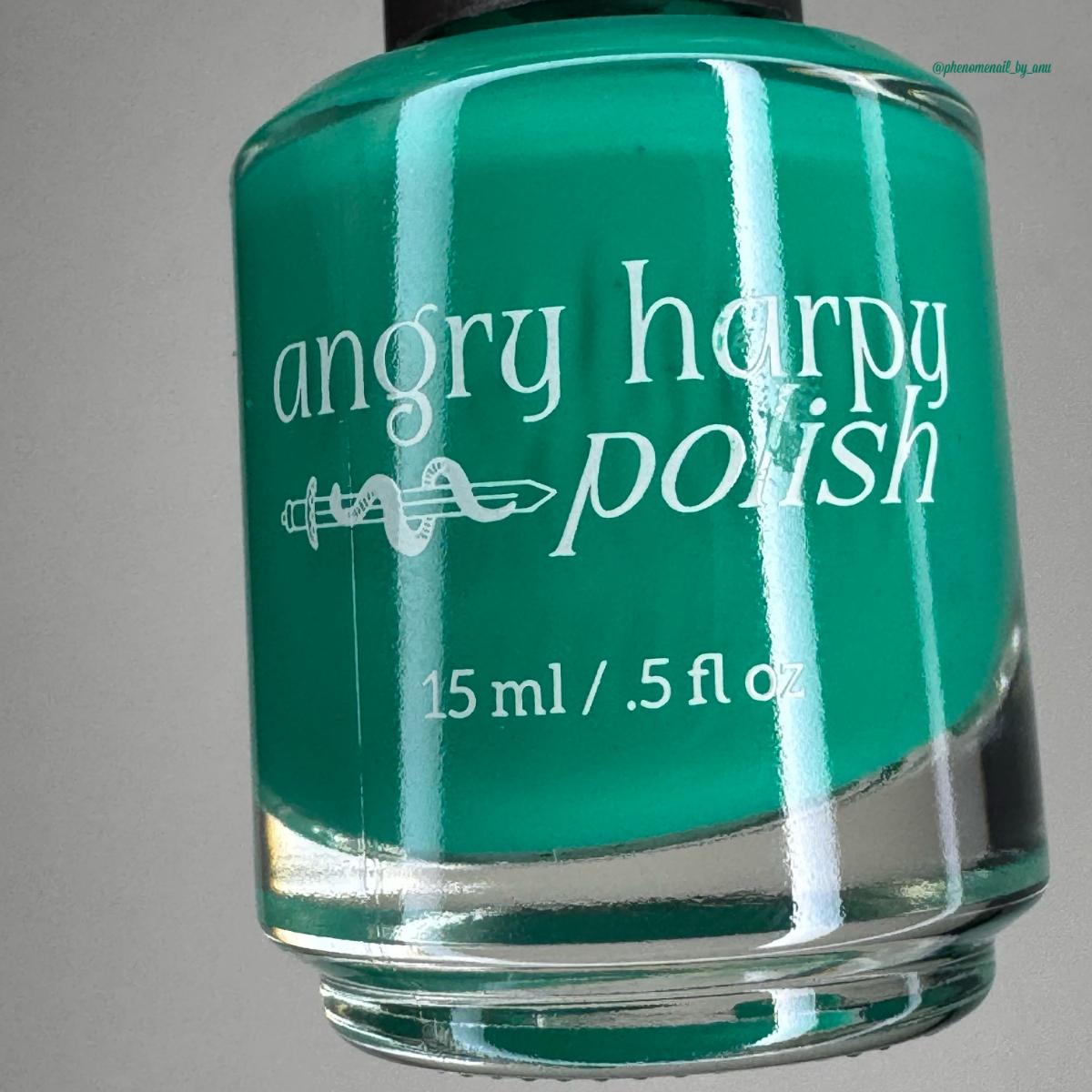 A close-up of a nail polish bottle filled with bright teal green polish, labeled 'angry harpy polish' in white text, against a plain gray background.